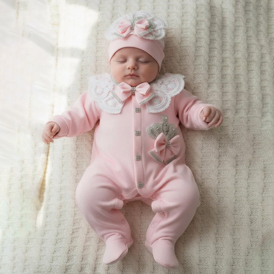 Pink newborn baby romper with lace collar, bow, and crown detail, perfect for luxury babywear.