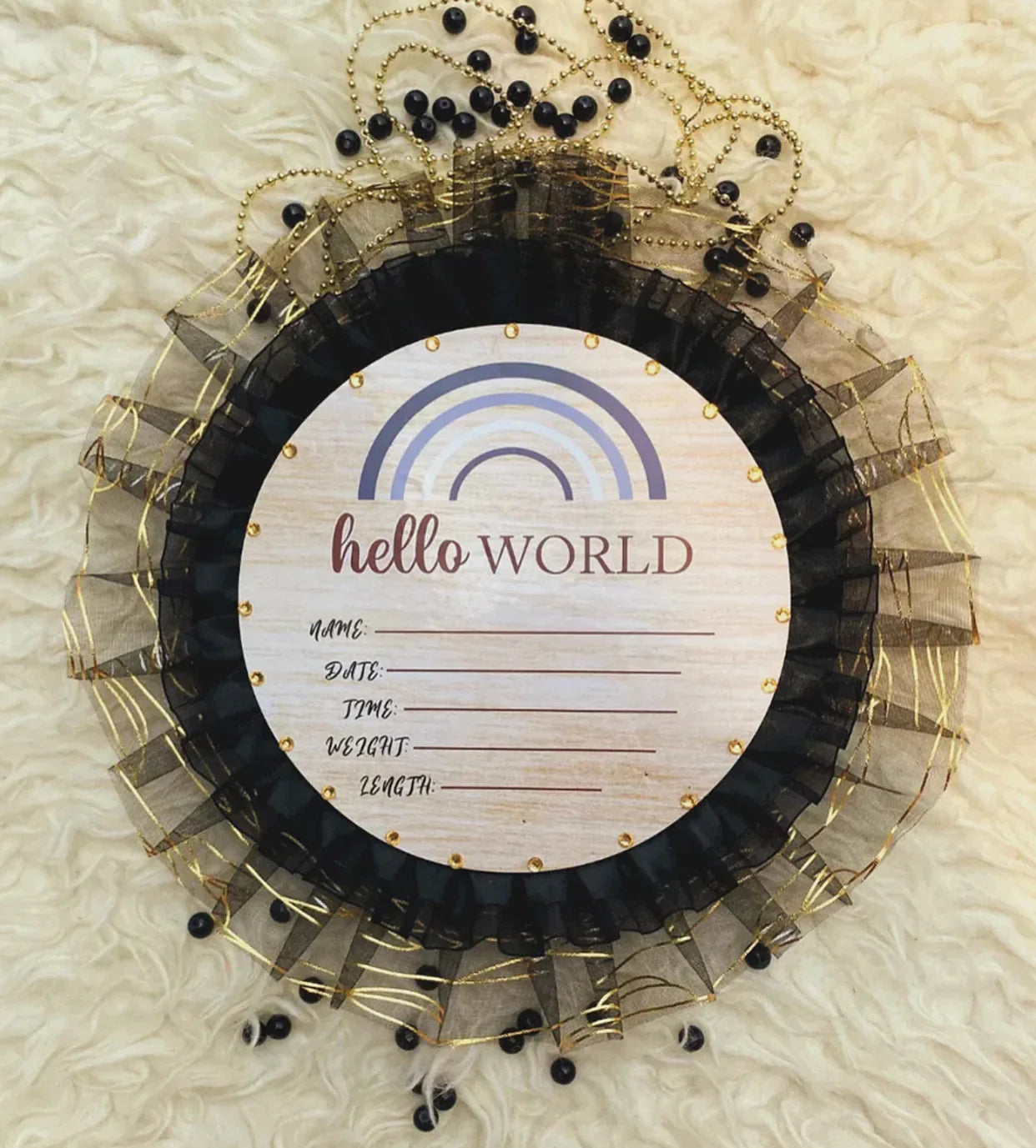 Hello World baby announcement sign with rainbow, black tulle, gold beads on soft white background