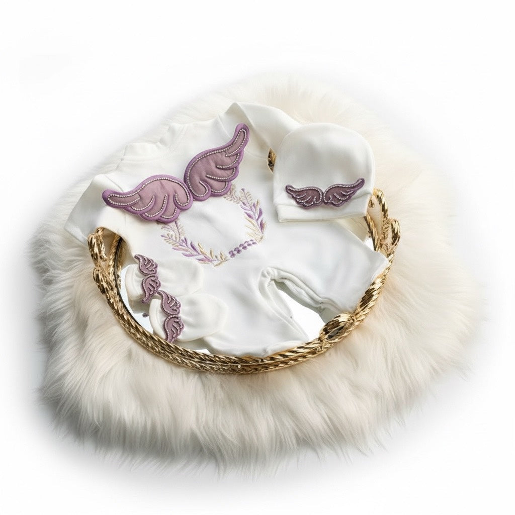 White baby romper with purple angel wings, matching hat & booties, luxury newborn set on fur