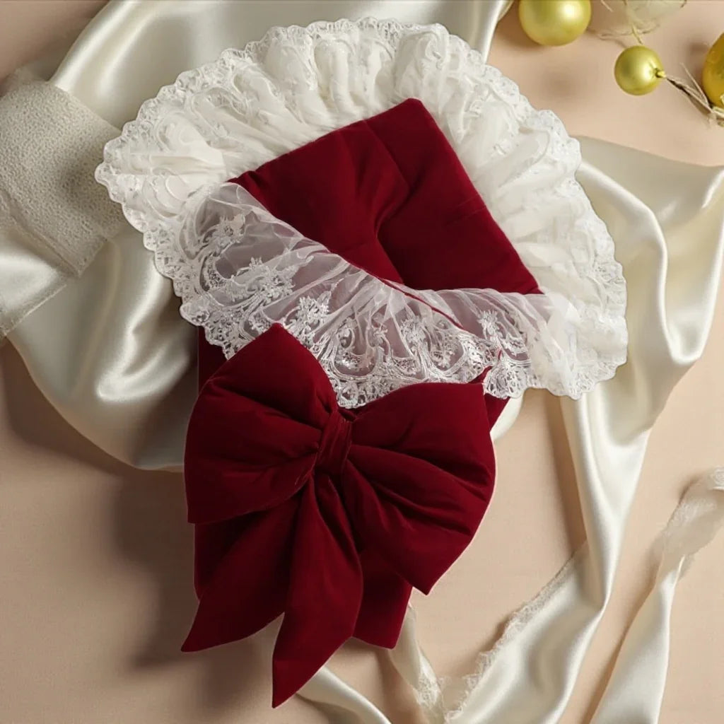 Luxury baby bonnet with red velvet bow and white lace trim, perfect for newborns and special occasions.