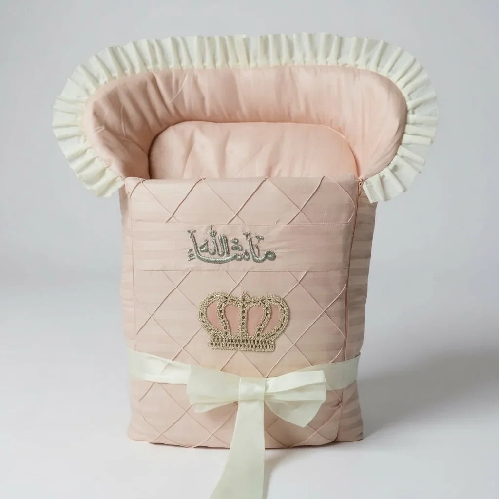 Pink quilted baby bassinet with crown embroidery and Arabic script, luxury newborn babywear
