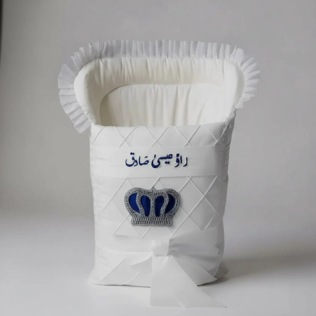 White quilted baby bassinet with blue crown embroidery and Urdu text, luxury newborn gift set